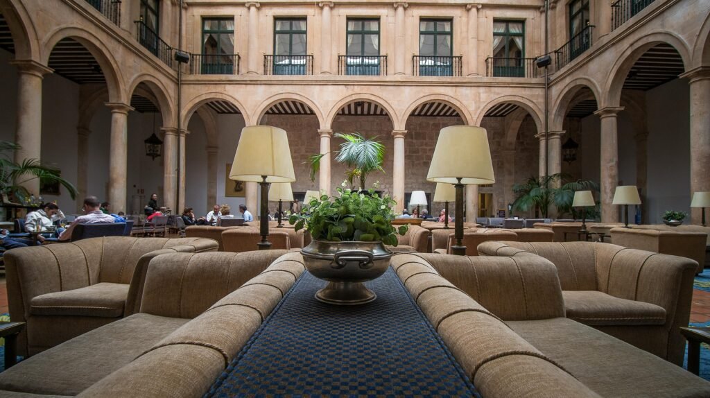 Beautiful hotel atrium with plush sofas, elegant arches, and lush greenery.